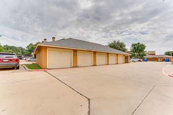 A two-car garage with a brown roof and tan walls. at Limestone Ranch Apartments, Lewisville, TX, 75067